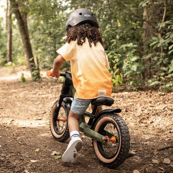 Child riding BERG Biky balance bike through the forest, adventurous and sturdy design