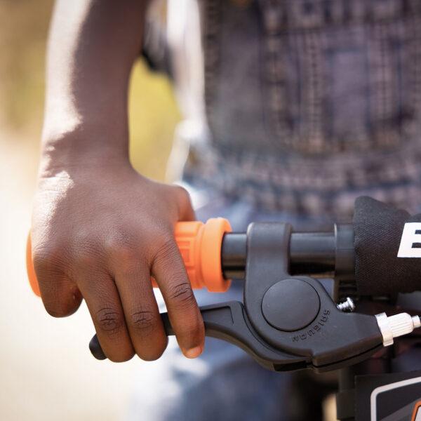 Main d’un enfant sur le vélo d’équilibre BERG Biky avec frein à main sécurisé