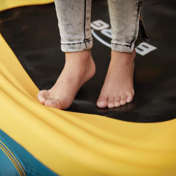 Bare feet on the jumping mat of the BERG Hoppaa toddler trampoline with soft protective edge