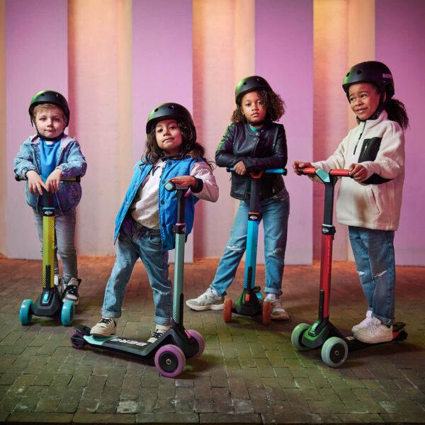 Four children with BERG Nexo scooters with light-up wheels