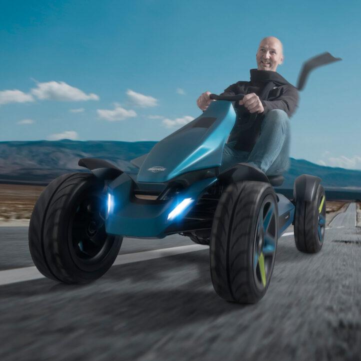 Driver rides a futuristic BERG Vision go-kart in a desert landscape