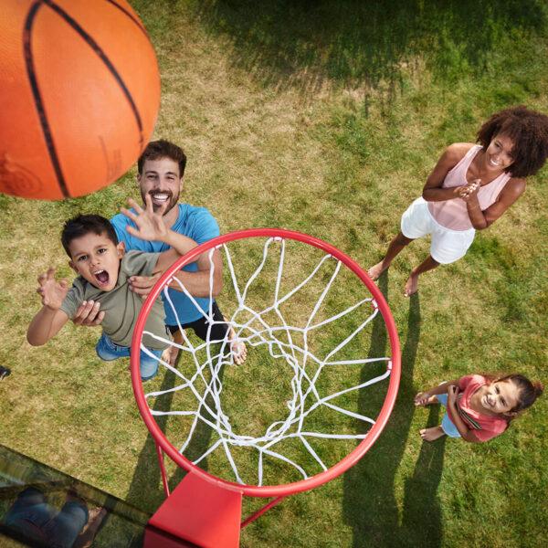 Familie spiller basketball på et BERG PlayBase lekestativ med basketballkurv