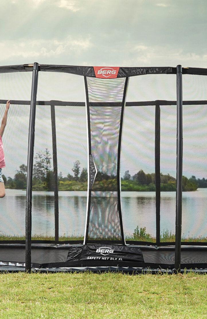 Child jumps on a BERG Ultim Elite trampoline for public use near a lake