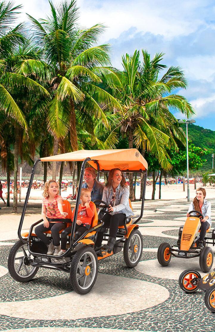 Familia disfruta de un paseo en BERG go-karts y el BERG Gran Tour a lo largo de una playa tropical