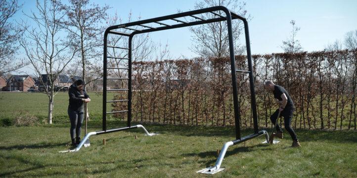 Step 2: The BERG PlayBase climbing frame is further assembled on a grass field