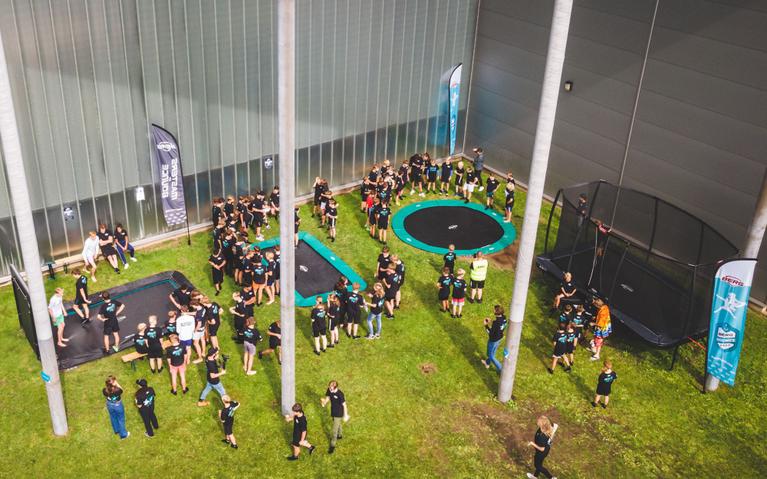 Vue d'ensemble d'un événement BERG Masters of Bounce avec trampolines et participants enthousiastes