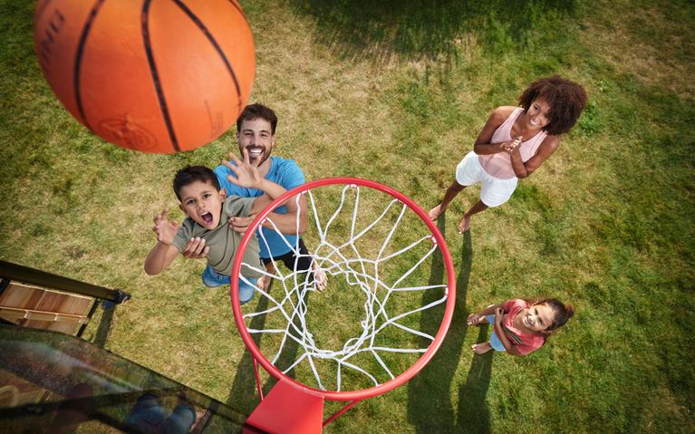 Children playing basketball on a BERG PlayBase climbing frame with basketball hoop