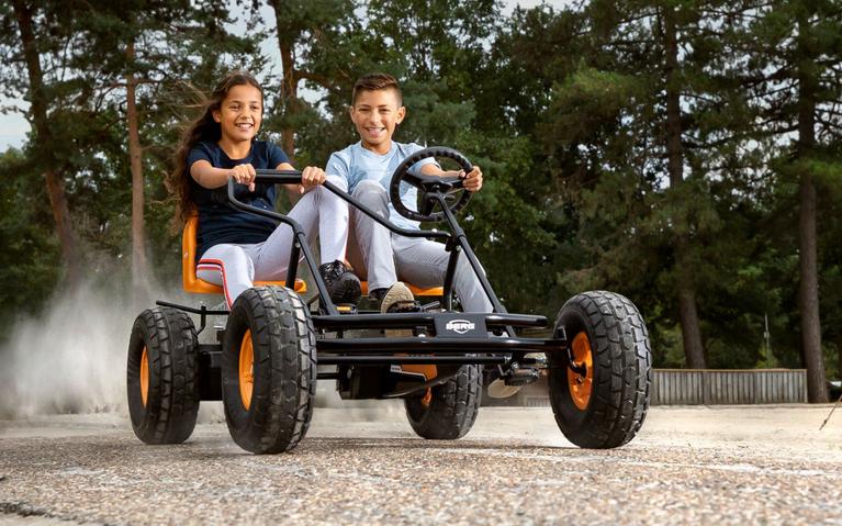 Niños conducen un BERG Duo Coaster - B2B por un camino aventurero