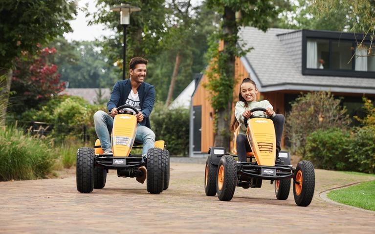 Padre e hija conducen BERG go-karts - B2B cerca de una casa de vacaciones