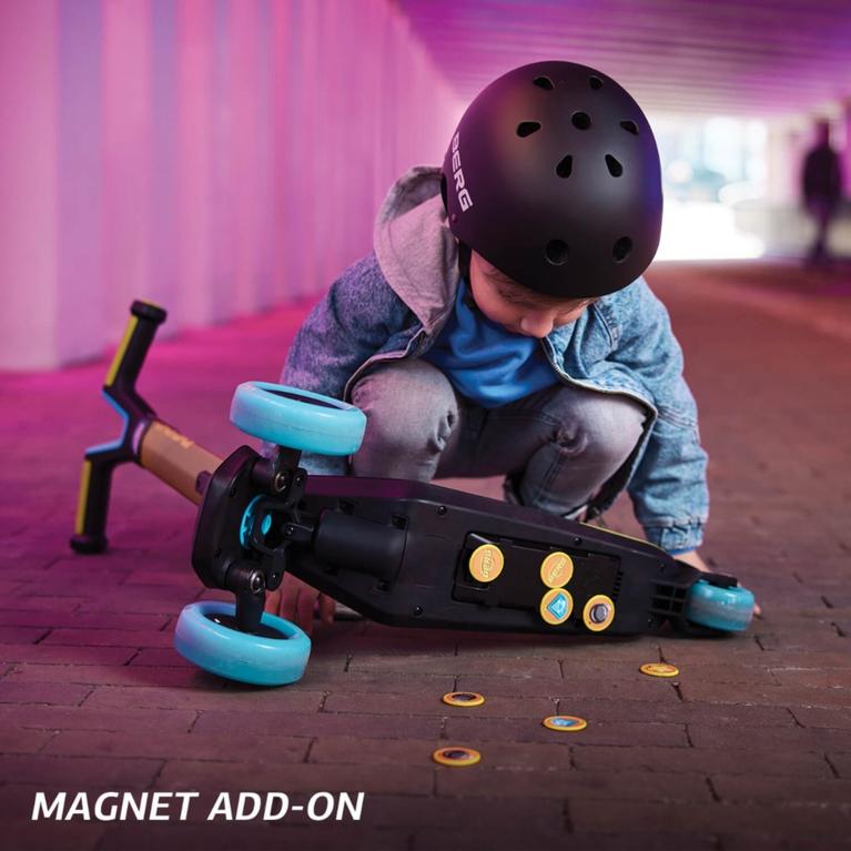 Child exploring the magnetic add-on on the underside of a BERG Nexo scooter