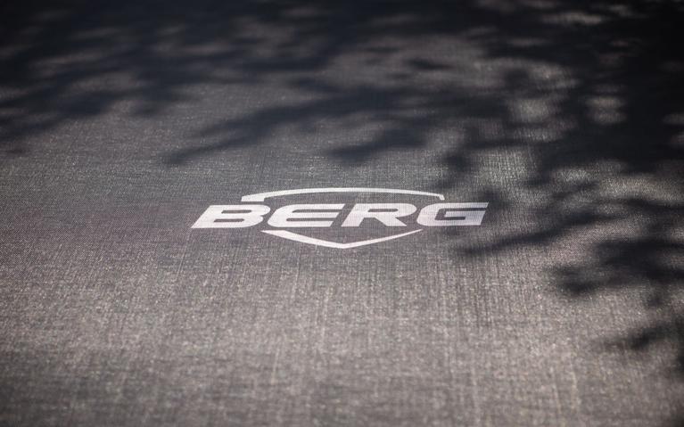 BERG trampoline jumping mat with logo and shadow of tree branches