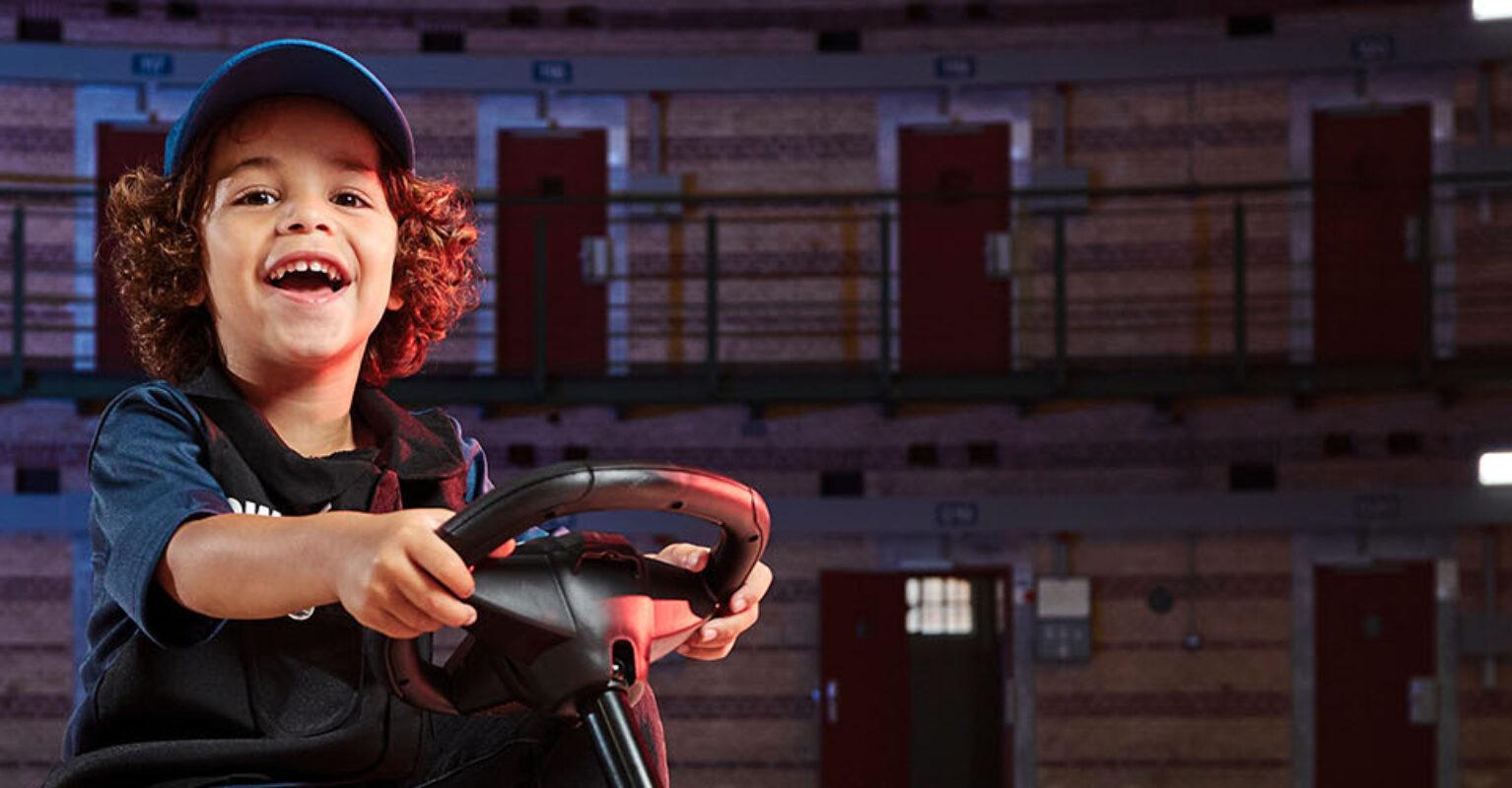 Happy child on BERG Buzzy Police go-kart in an atmospheric setting