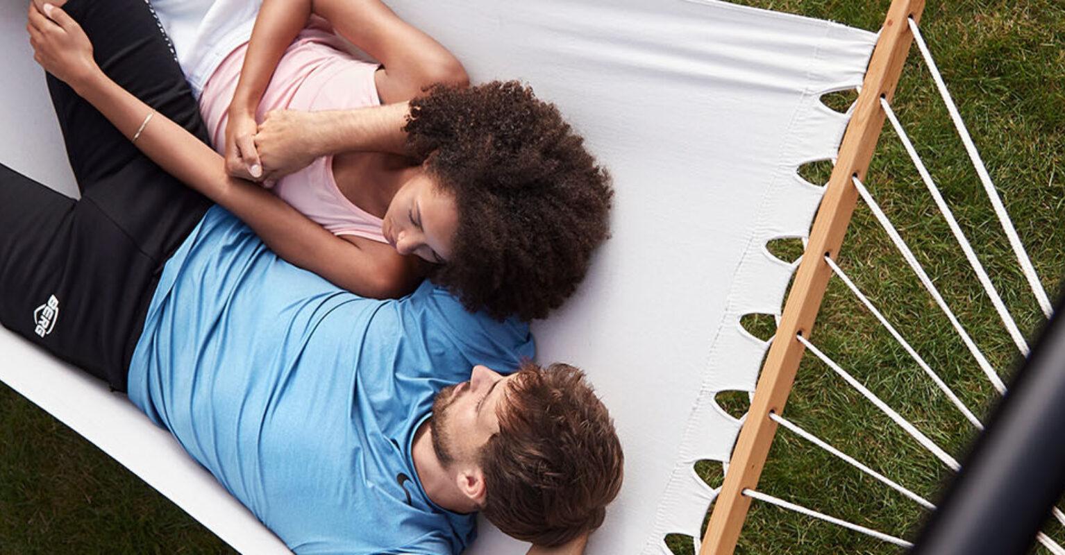 Two people relaxing in a hammock on a BERG PlayBase climbing frame