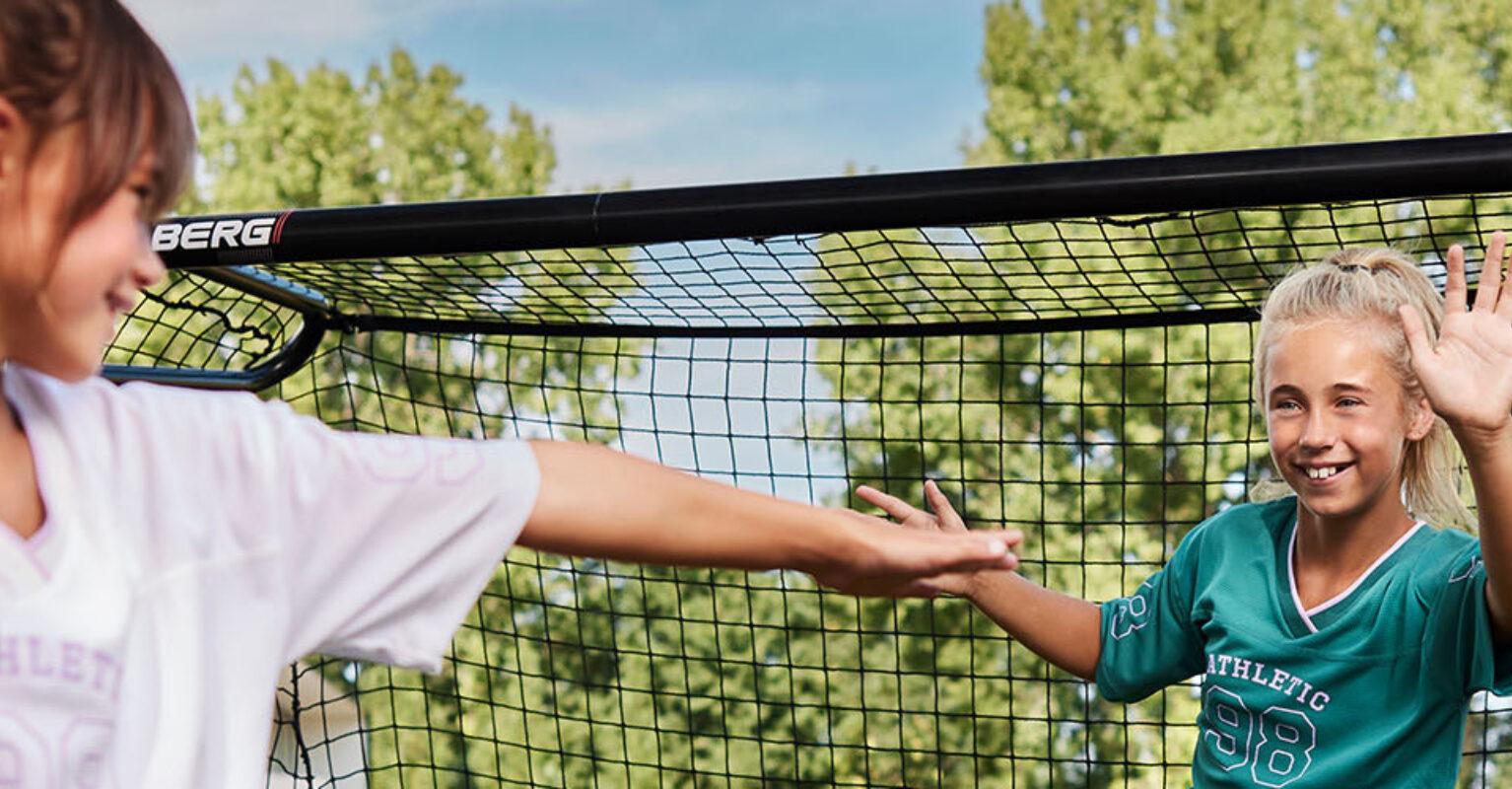 Children playing handball near a BERG SportsGoal in the garden – banner