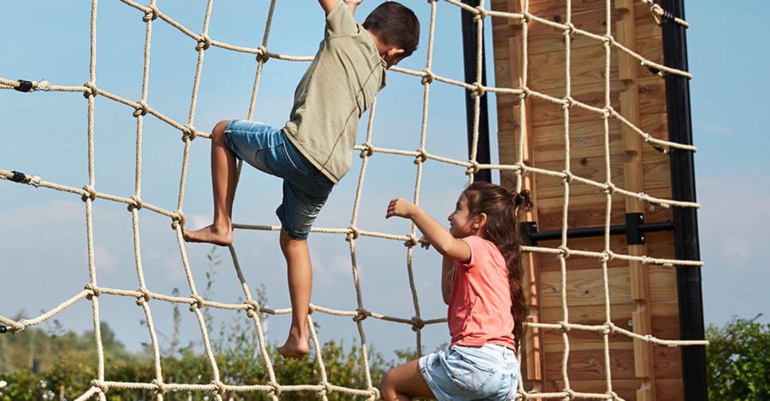 Banner with children climbing on a BERG PlayBase climbing frame with a climbing net