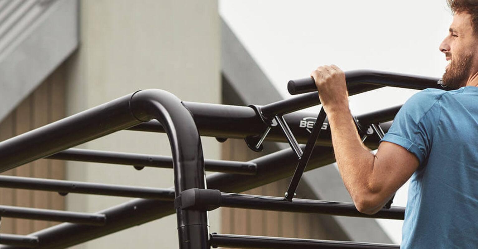 Banner with man performing pull-ups on a BERG PlayBase climbing frame