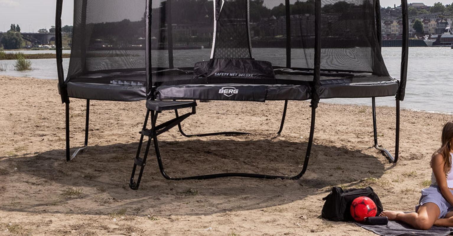 Banner featuring BERG Elite Regular trampoline on the beach with people relaxing